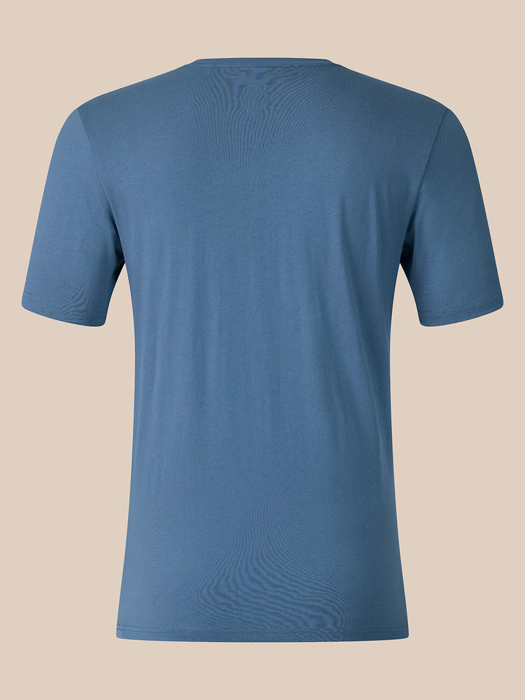 A short-sleeve crewneck t-shirt in a dusty slate blue color, shown from the back against a solid beige background.